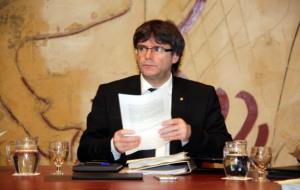 El president de la Generalitat, Carles Puigdemont, mira a la seva dreta amb posat seriós i un informe a la mà al Consell Executiu. ACN