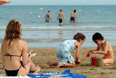 Nens i nenes jugant a la platja. Eix