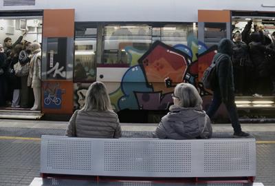 Dues usuàries de Rodalies assegudes a un banc a l'estació . ACN / Jordi Pujolar